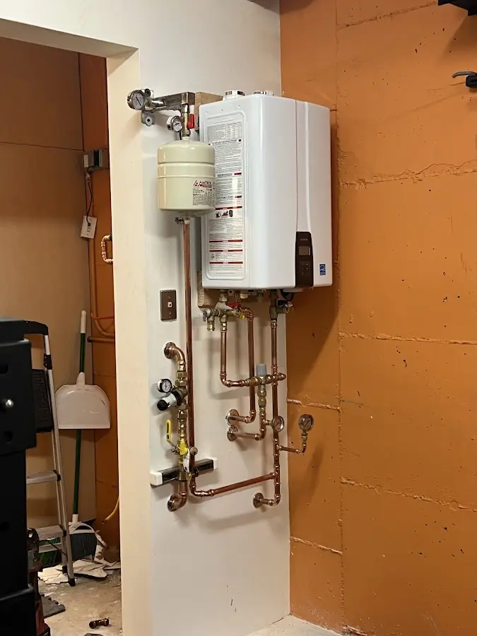 Plumbing technician inspecting water heater connections in Bull Run
